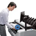 HP T2600 showing a person loading a paper roll in the machine