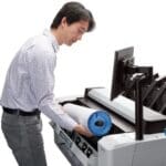 HP T2600 showing a person loading a paper roll in the machine